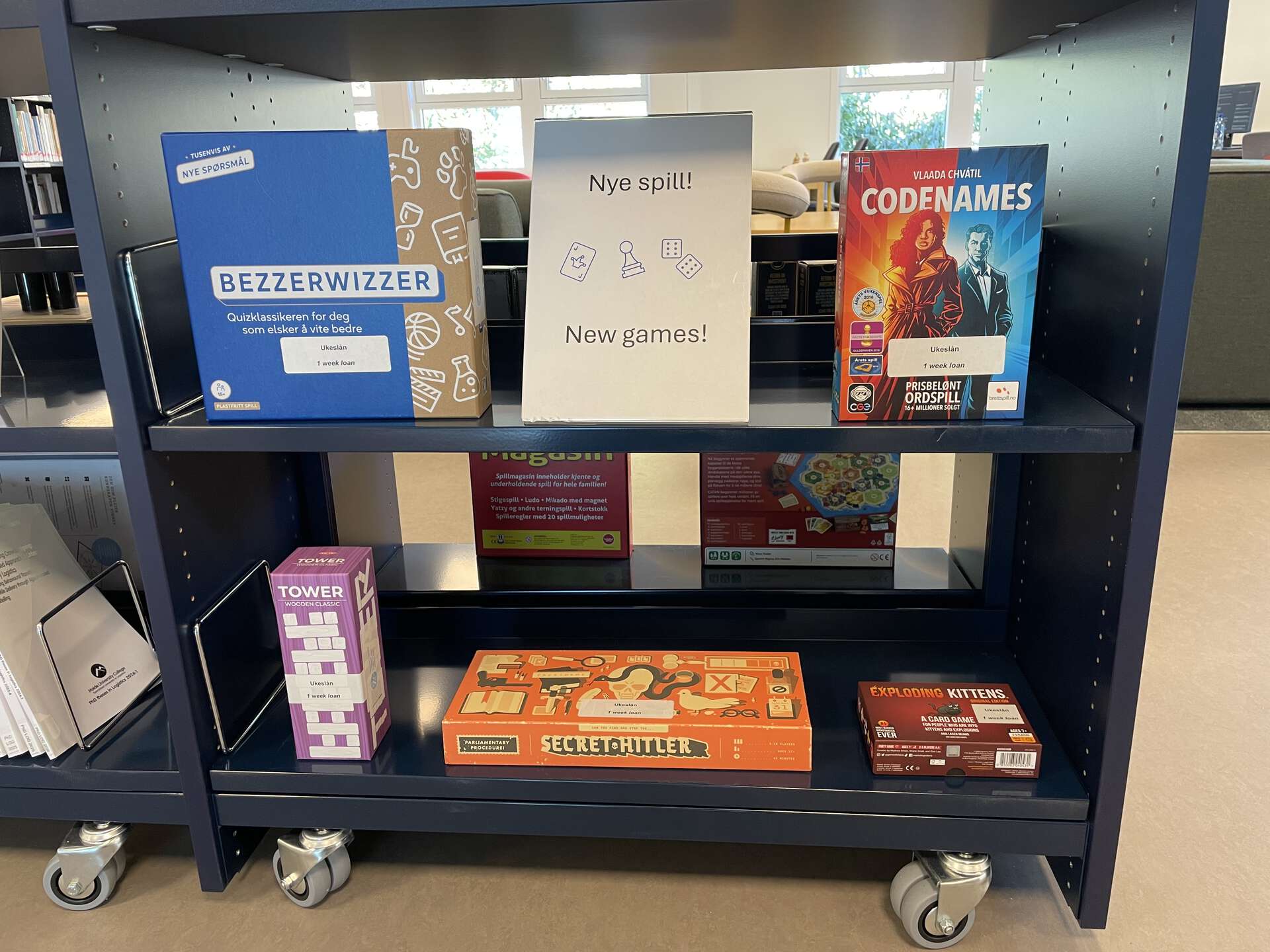 Bildet viser noen av de nye spillene på biblioteket: Bezzerwizzer, Codenames, Tower, Secret Hitler, og Exploding Kittens.