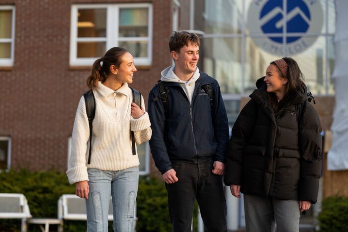 Tre studenter utenfor Høgskolen i Molde.