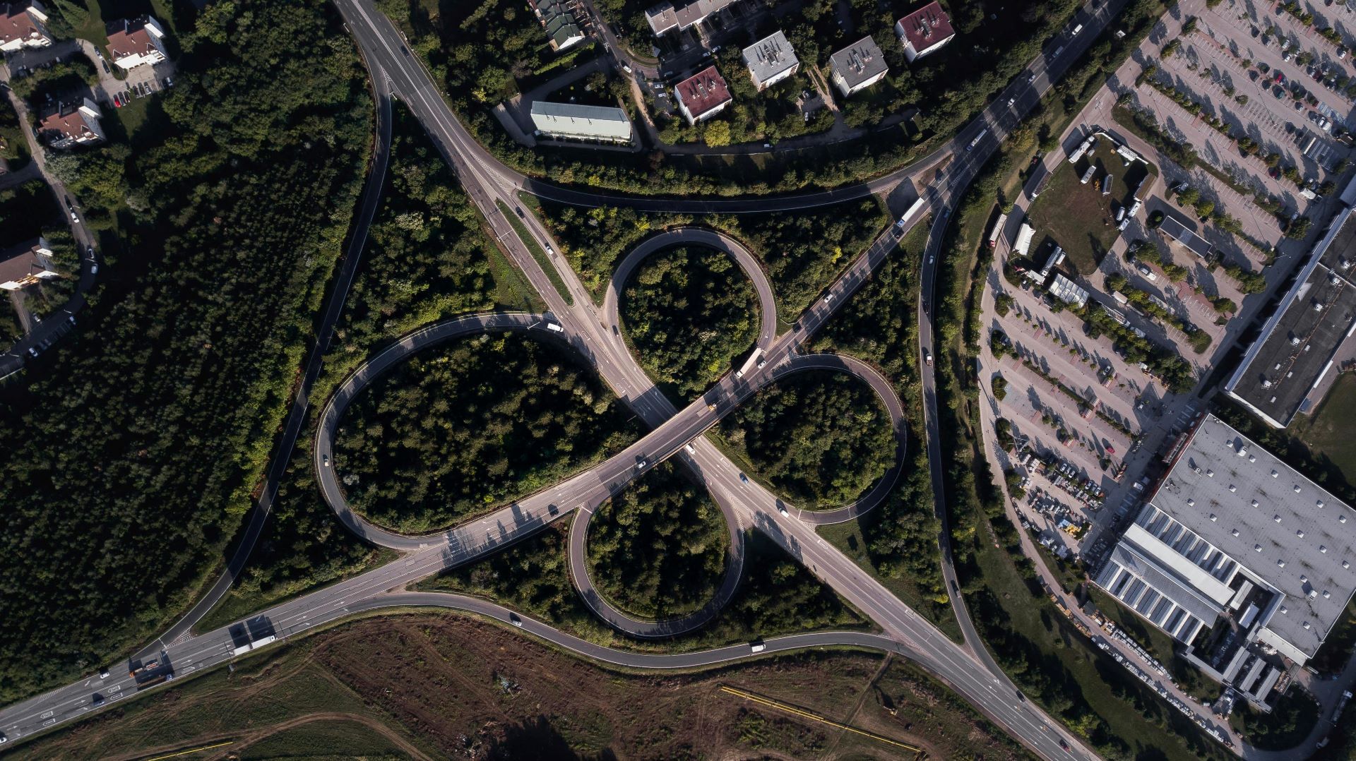 motorvei omringet av grønn skog sett fra lufta