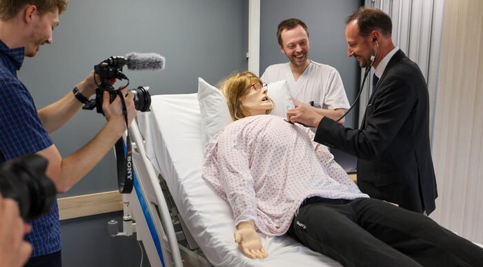 Bilde av kronprins Haakon lytter med stetoskop på "Gjertrud".