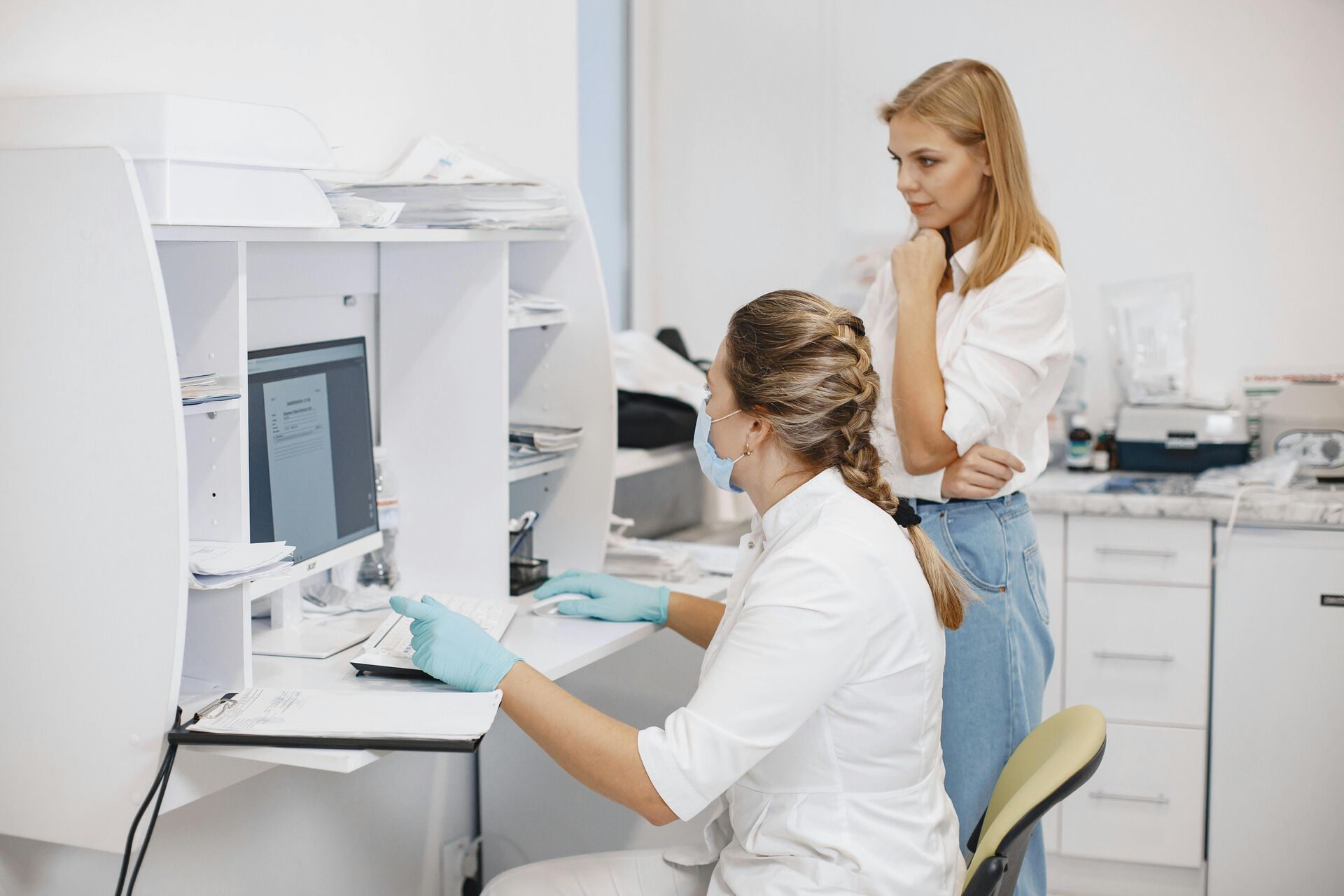 Two women looking at a computer screen in a clinical setting. 