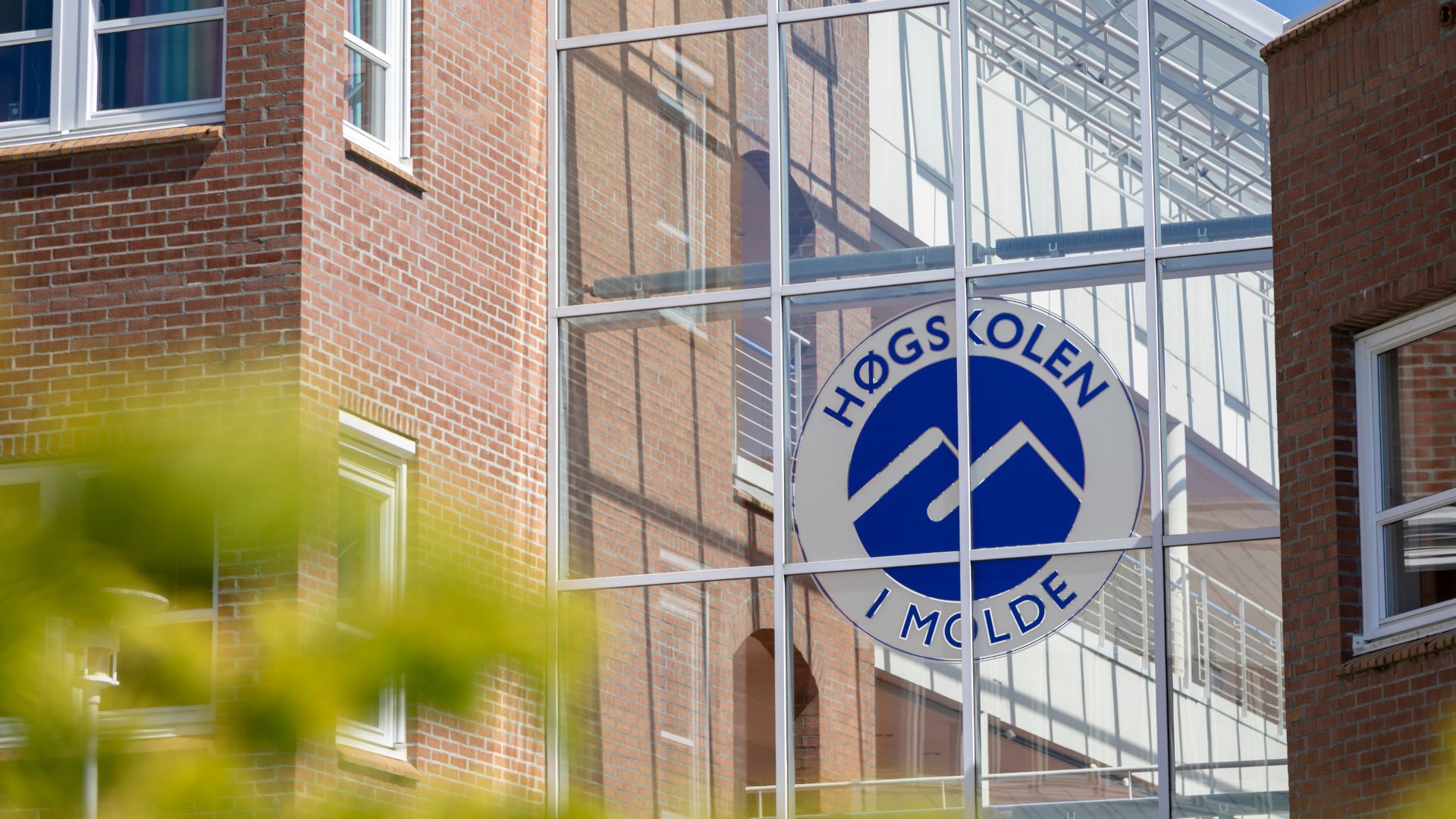Inngangsparti på Molde Campus. Glassfasade med logoen til Høgskolen i Molde. 